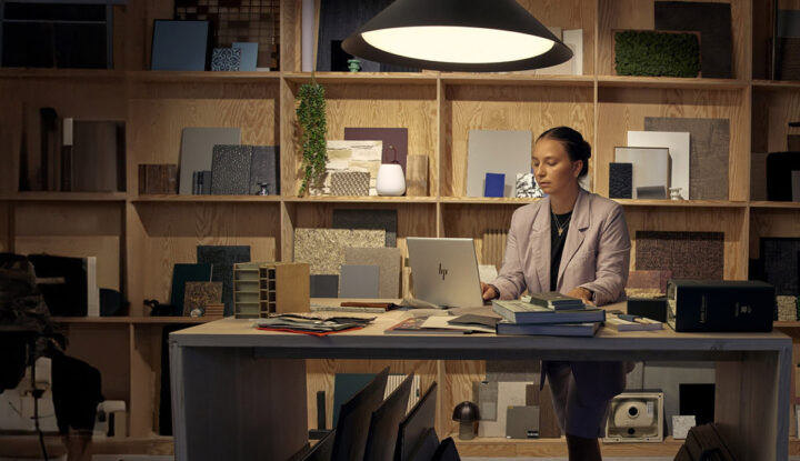 A person standing at a desk using a laptop