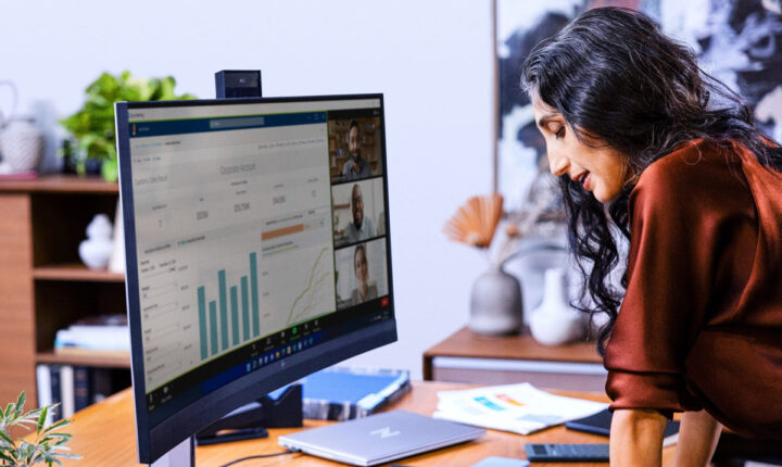 A person stands at a desk whilst on a video call
