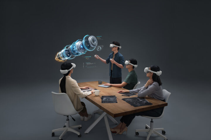 People sitting at a desk wearing VR goggles