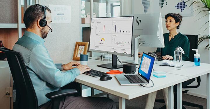 2 people working at computer in an office