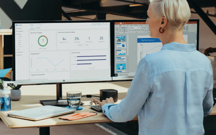A person working at a computer with 2 big monitors