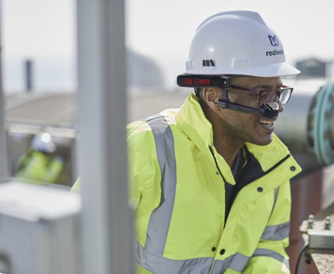 A person wearing a high-vis jacket and a RealWear headset