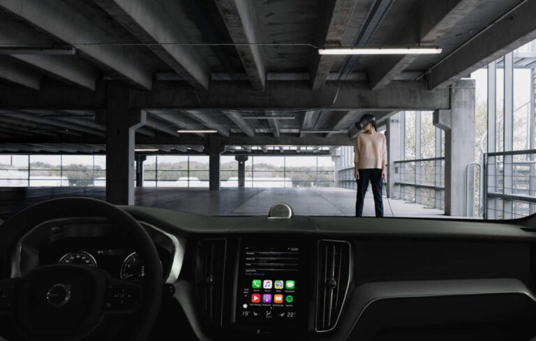 The view from inside a car, looking at a person wearing a VR headset
